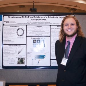 Spencer Mickus next to his poster at the Symposium