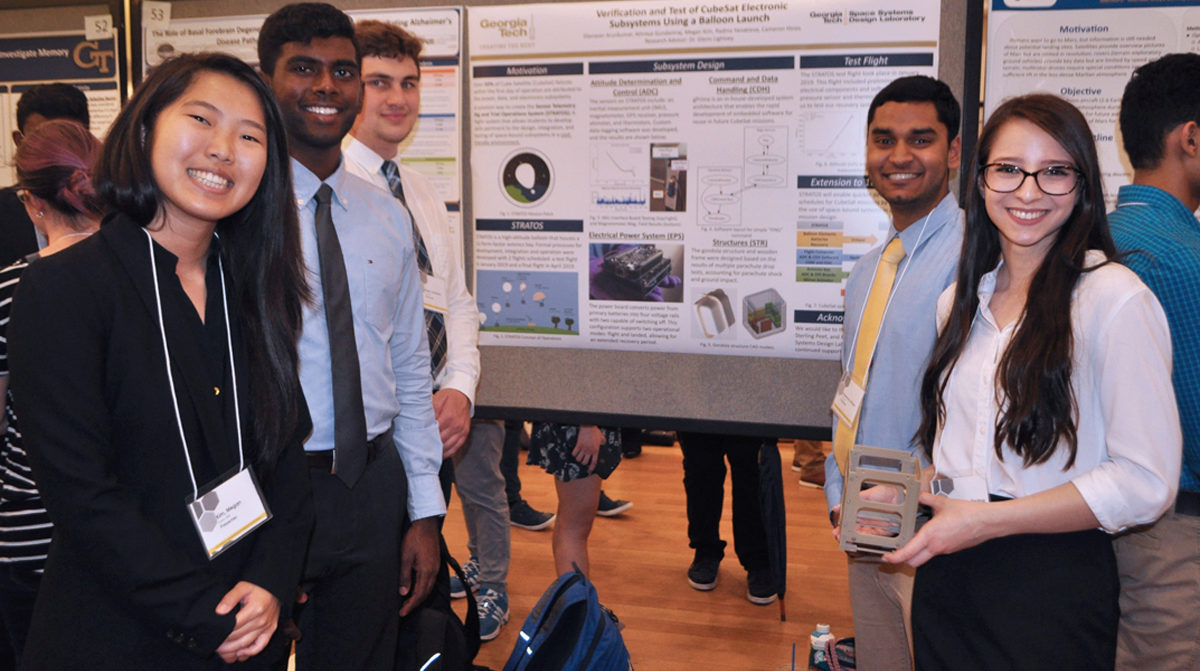 Six student researchers standing in front of their poster at the Symposium