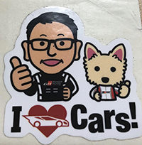The sticker that Toyoda gave Kozel: a cartoon image of a man and a dog with the words 'I love cars'