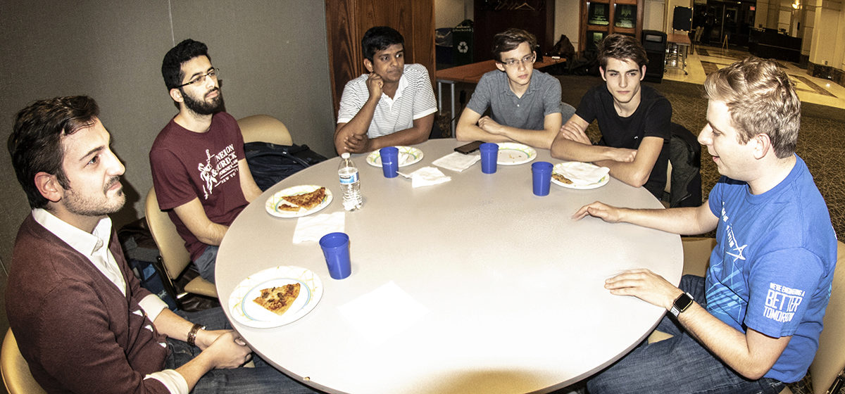 AE alumnus Ryan Burke, right, explains some of the details of the Lockheed Martin Challenge to AE students