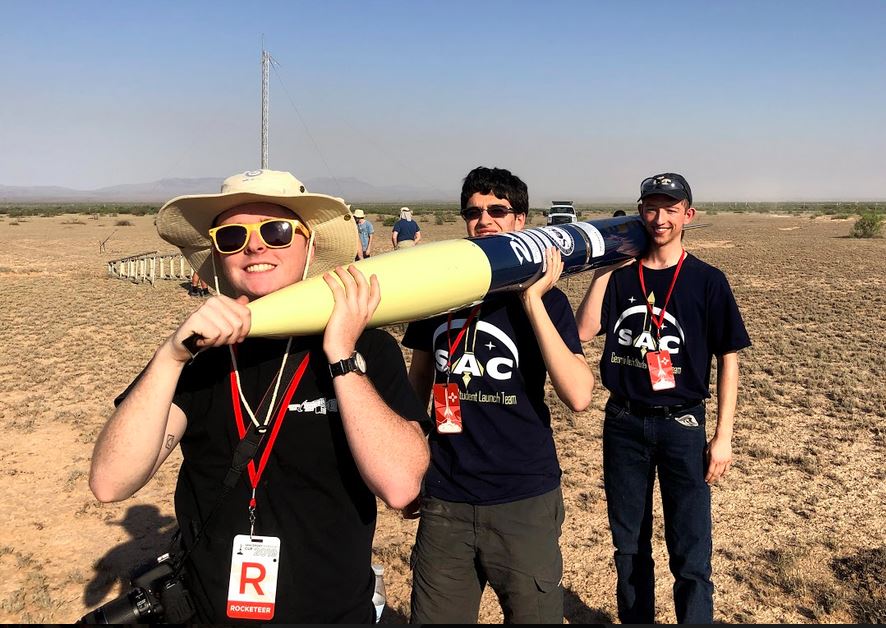 Carson Coursey, Nick Brophy and Taha Krarti carrying the rocket