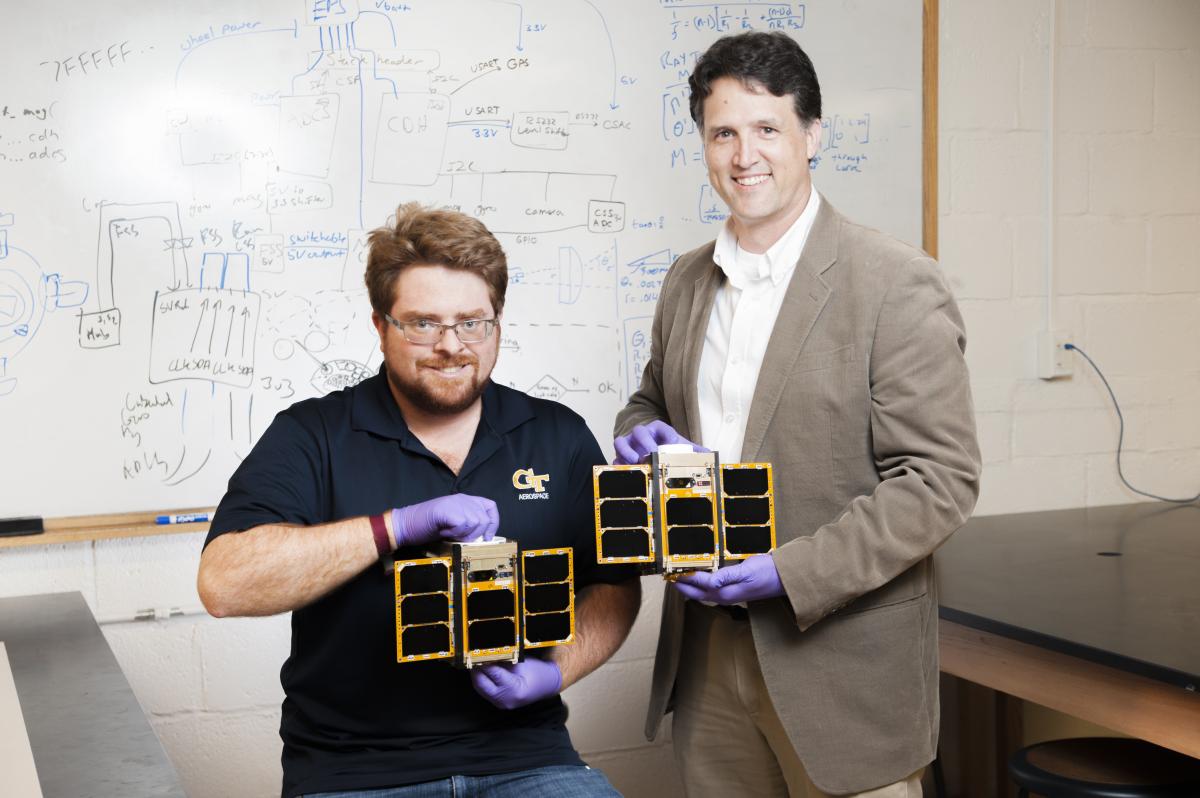 brian guner and a sresearcher holding a cubesat developed at georgia tech 