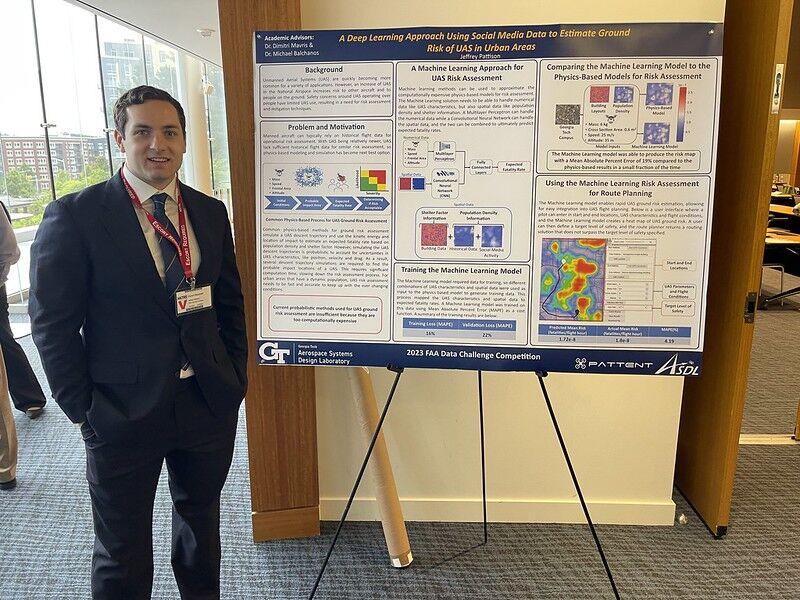 Jeffrey Pattison standing next to his FAA competition poster